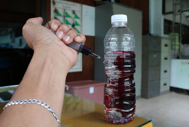 Männer injizieren Blut ins Trinkwasser. - Foto, Bild