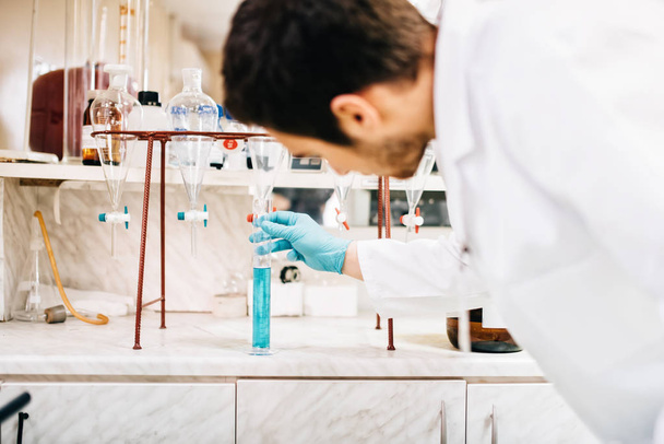 αρσενικό επιστήμονας χρησιμοποιώντας εργαστήριο εργαλεία, σωλήνες δοκιμής σε κλινική, φαρμακείο και εργαστηριακή ιατρική έρευνα  - Φωτογραφία, εικόνα