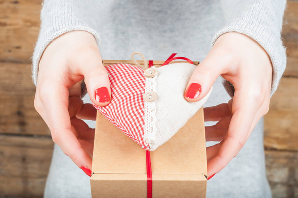 Kraft kutusunda ahşap arka plan üzerinde hediye holding eller. Konsantrasyon - Fotoğraf, Görsel