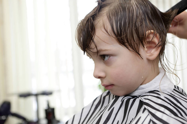 Barber cutting hair of child - Foto, Imagen