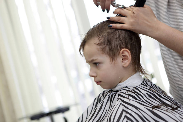 Barber cutting hair of kid - Foto, afbeelding
