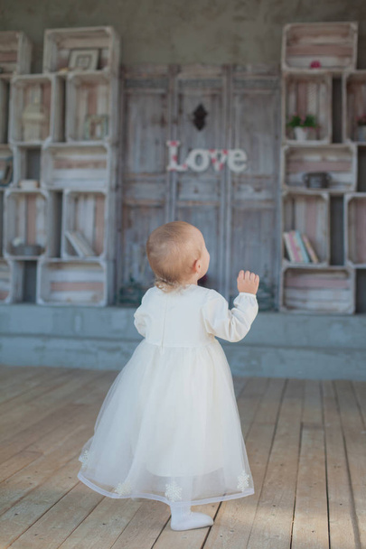 Very cute little girl blonde in a white dress on room in vintage style - Foto, Imagem