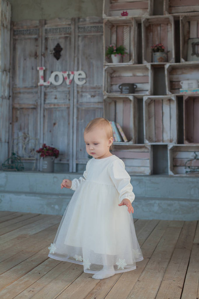 Very cute little girl blonde in a white dress on room in vintage style - Valokuva, kuva