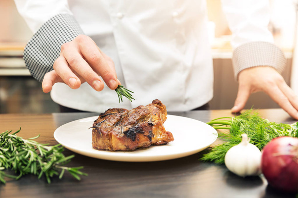 chef decorare carne arrosto con erbe
 - Foto, immagini