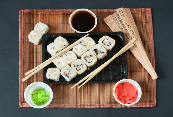 Différents types de rouleaux de sushi sur fond noir. Concept Sushi à emporter
 - Photo, image