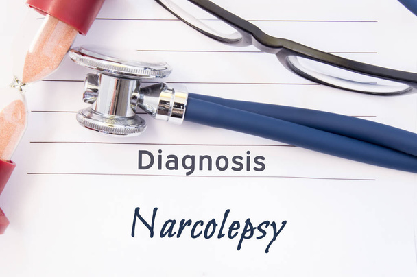 Diagnosis Narcolepsy. Psychiatric diagnosis Narcolepsy is written on paper, on which lay stethoscope and hourglass for measuring time to research. Concept photo for psychiatry or psychology - Photo, Image