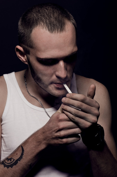 Young man lights a cigarette - Fotó, kép