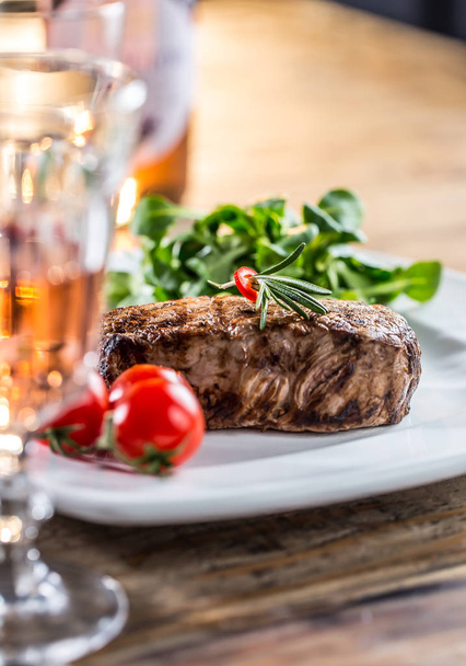 Beef Steak. Juicy beef steak. Gourmet steak with vegetables and glass of rose wine on wooden table - Foto, afbeelding