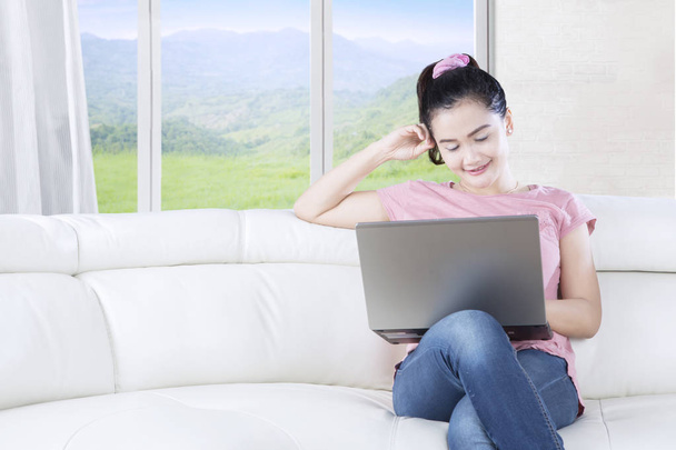 Woman browsing internet on couch - Zdjęcie, obraz