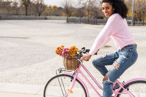 Musta nuori nainen ratsastus vuosikerta polkupyörän
 - Valokuva, kuva