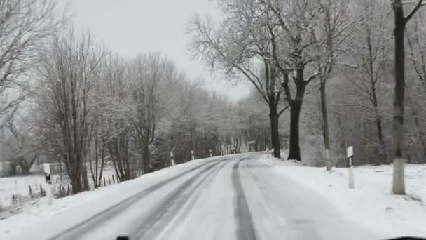 jadąc wzdłuż drogi w okresie zimowym. Snowy i śliski - Materiał filmowy, wideo