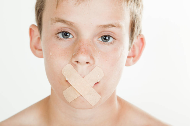 Boy with adhesive bandage across his mouth - Photo, Image