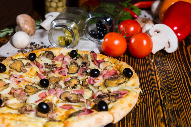 Tasty pizza with ham and black olives on wooden table and other  - Фото, зображення
