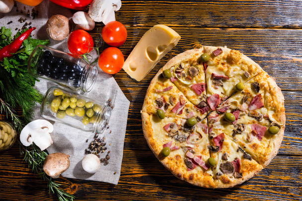 High angle view of pizza with olives, near lie cheese and other  - Foto, afbeelding