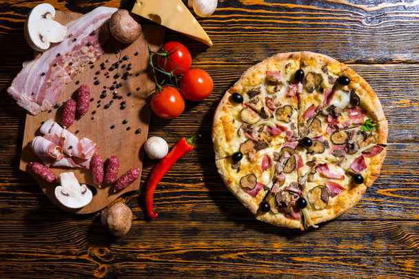 High angle view of pizza, tomatoes, near lies mushrooms and cutt - Fotoğraf, Görsel