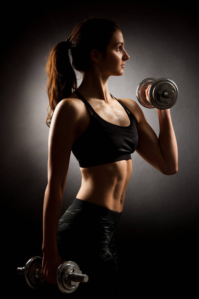 Atractive fit woman works out with dumbbells as a fitness concep - Foto, Imagen