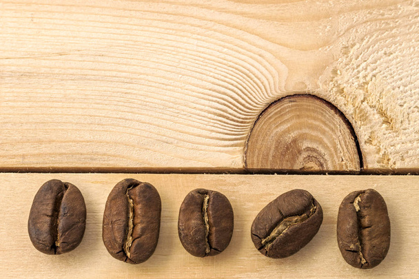 Grains de café marron sur fond de panneau en bois texturé jaune cl
 - Photo, image