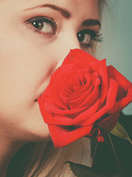 Gorgeous woman holding red rose flower. - Zdjęcie, obraz