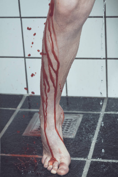 Bein und Fuß des Jungen unter der Dusche, Blut fließt nach unten - Foto, Bild