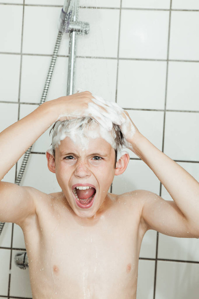 Menino gritando no chuveiro enquanto lavava o cabelo
 - Foto, Imagem