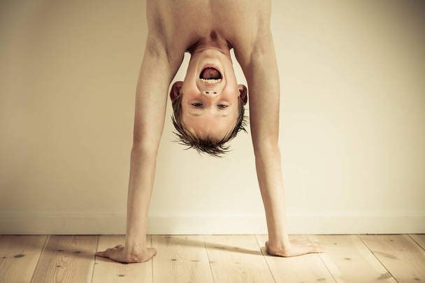 Αγόρι ουρλιάζοντας κάνοντας ένα handstand - Φωτογραφία, εικόνα