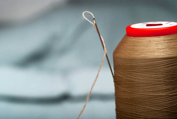Detail of a needle with thread in the workroom tailor - Photo, Image