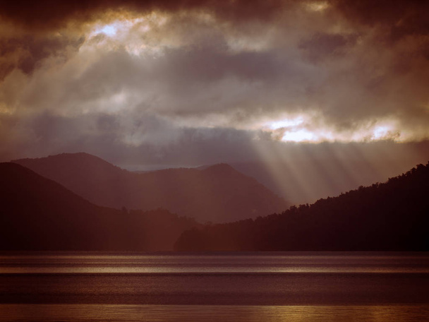Raggi di sole che splendono attraverso le nuvole sul lago di montagna nebbioso in vinta
 - Foto, immagini