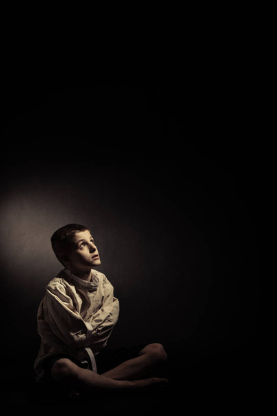 Thoughtful Lonely Boy Sitting in an Isolated Room - Фото, изображение