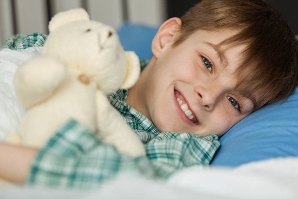 Happy Boy with his Teddy Bear Lying on his Bed - Fotoğraf, Görsel