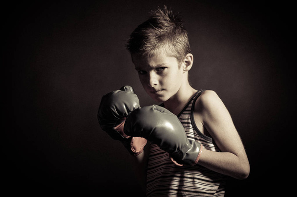 Boxer Boy com luvas franzindo a testa na câmera
 - Foto, Imagem