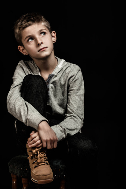 Συλλογισμένος νεαρό αγόρι κάθεται σκέψης - Φωτογραφία, εικόνα