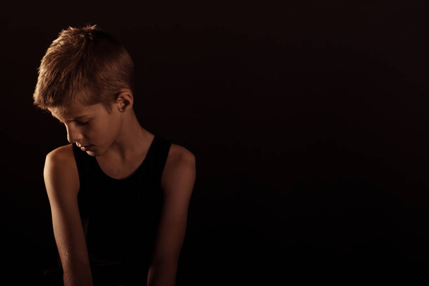 einsamer schlanker Junge gegen Schwarz mit Kopierraum - Foto, Bild