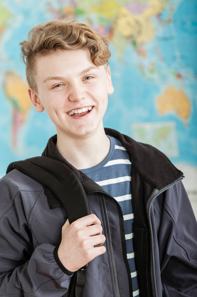 Усміхнений хлопчик стоїть в класі Холдинг Knapsack
 - Фото, зображення
