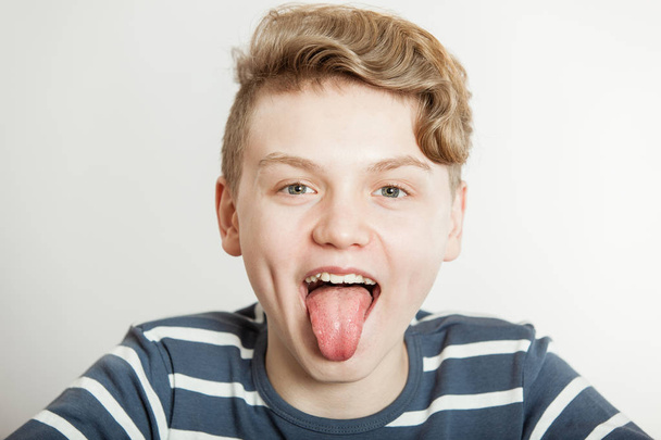 Jovem rapaz a estender a língua
 - Foto, Imagem
