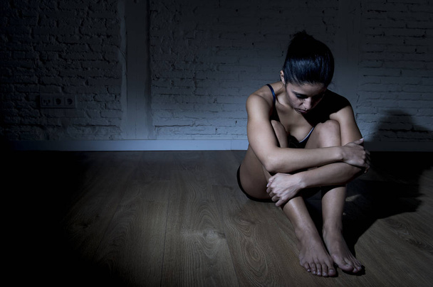 joven hermosa latina mujer o adolescente chica sentado triste y solo en la oscuridad nerviosa sensación de depresión
 - Foto, Imagen