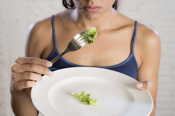 Młoda kobieta gospodarstwa danie z śmieszne sałata jako jej jedzenie symbol szalony dieta zaburzenia odżywiania - Zdjęcie, obraz