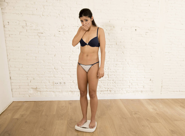 nuori istuvuus hoikka nainen tai teini tyttö tarkkailun kehon painoa mittakaavassa löytää itsensä rasvaa
 - Valokuva, kuva