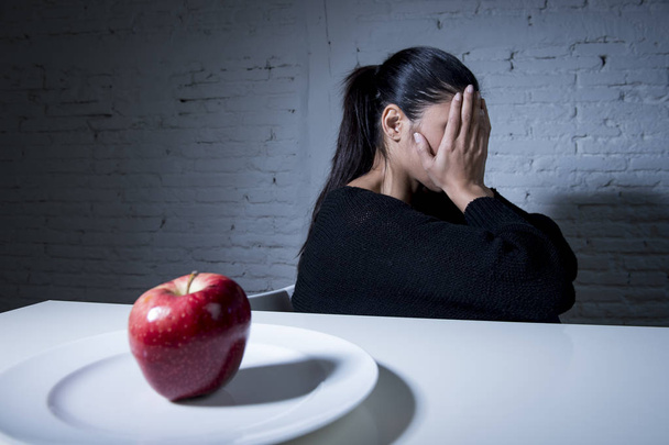 mujer joven o adolescente con fruta de manzana en el plato como símbolo de la dieta loca en el trastorno nutricional
 - Foto, Imagen