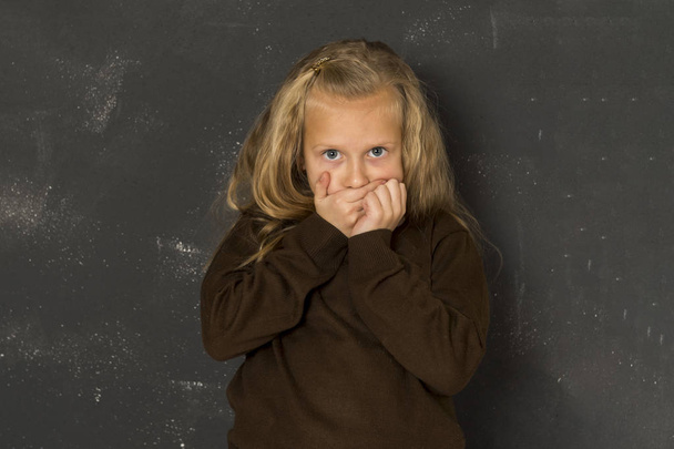  beautiful blond schoolgirl sad moody and tired in front of school class blackboard - Photo, Image
