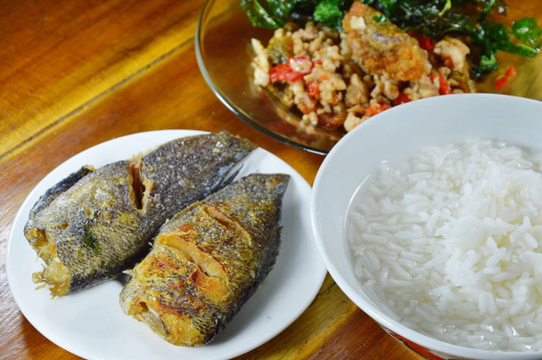 arroz cozido comer com folha de manjericão crocante frito com ovo preto preservado e peixe frito
 - Foto, Imagem