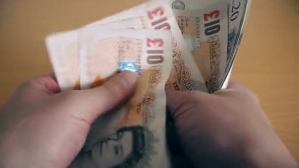 The man counts money at the table. (British Pound) - Séquence, vidéo