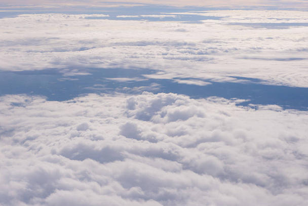 Mavi gökyüzü ve bulutlar uçağın penceresinden görüldüğü gibi - Fotoğraf, Görsel