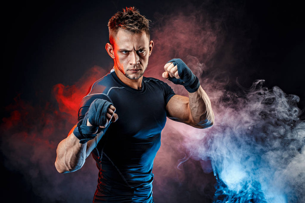 Studio portrait of fighting muscular man in smoke - Foto, Imagem