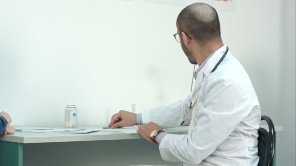 Smiling doctor giving little patient a lollipop after the exam - Video, Çekim