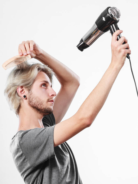 Young man drying hair with hairdryer - Φωτογραφία, εικόνα