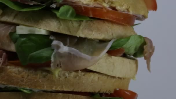 GANT σάντουιτς γεμιστό με πολλά στρώματα του ψωμιού με μαρούλι ντομάτα τυρί σαλάμι  - Πλάνα, βίντεο
