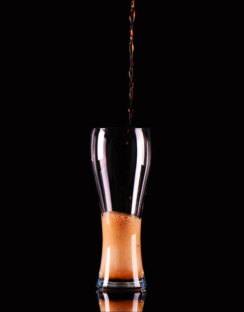 Glass with dark beer or kvass with foam on black background. - Photo, image