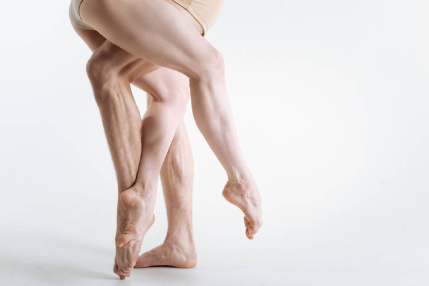 Strong gymnastics legs located in the white colored studio - Zdjęcie, obraz