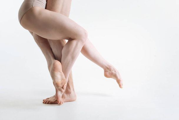Flexible dancers legs performing in the white colored room - Fotó, kép
