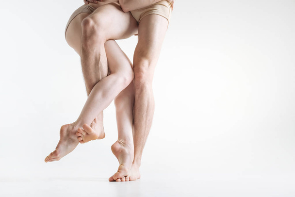 Flexible dancers legs performing in the white colored room - Foto, Imagem